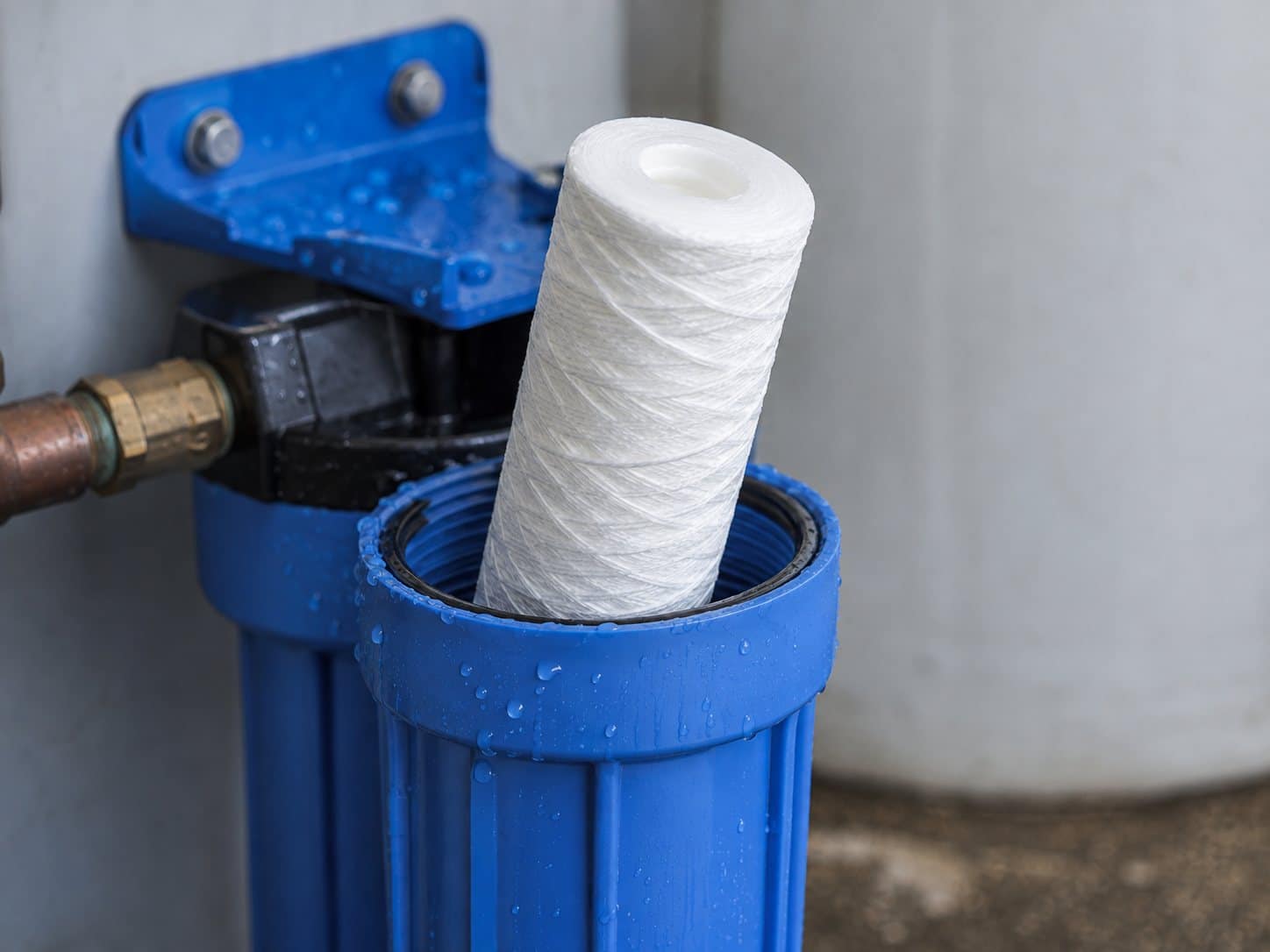 New sediment filter cartridge being installed in a filter housing