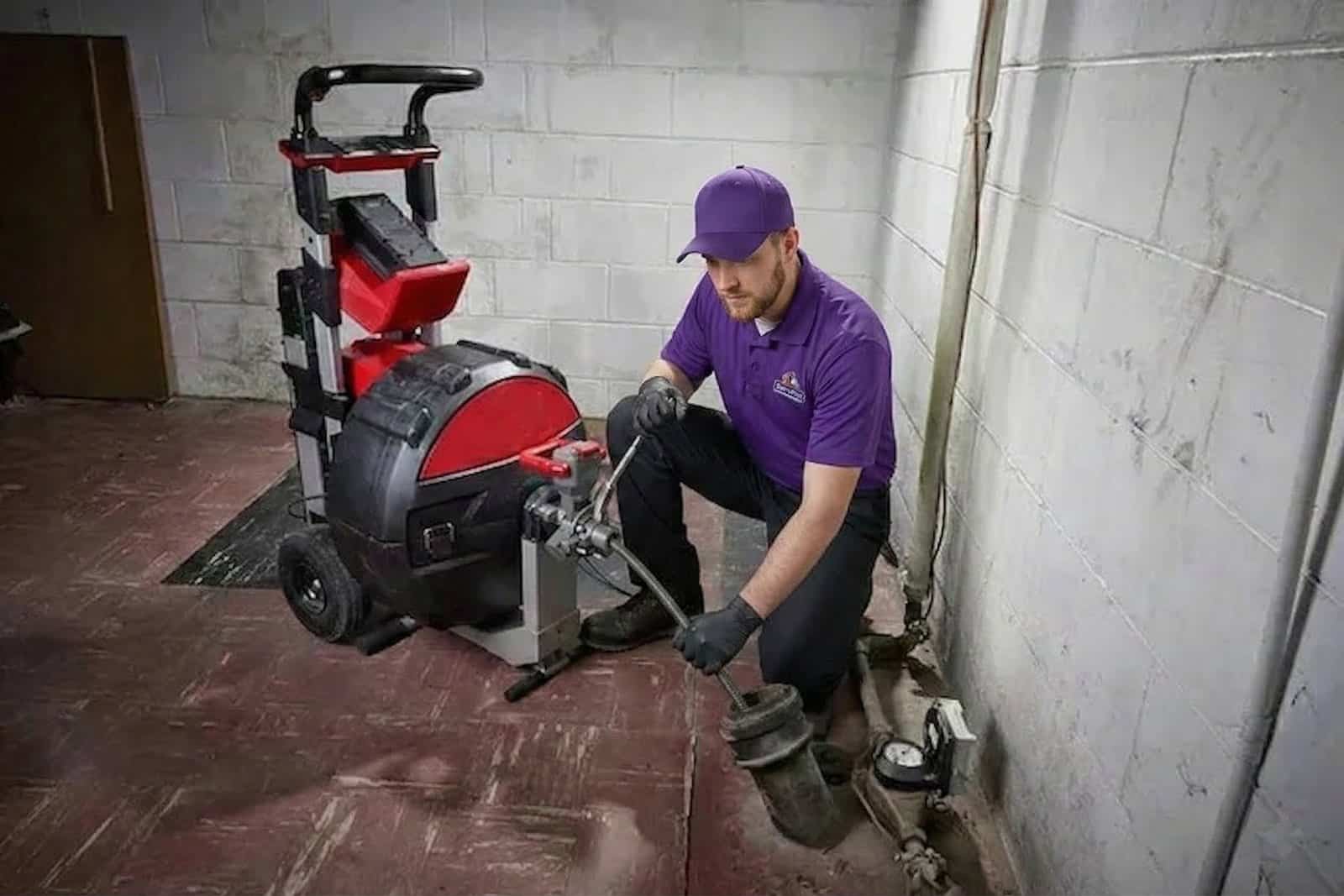 ServiStar technician running a drain machine at a cleanout