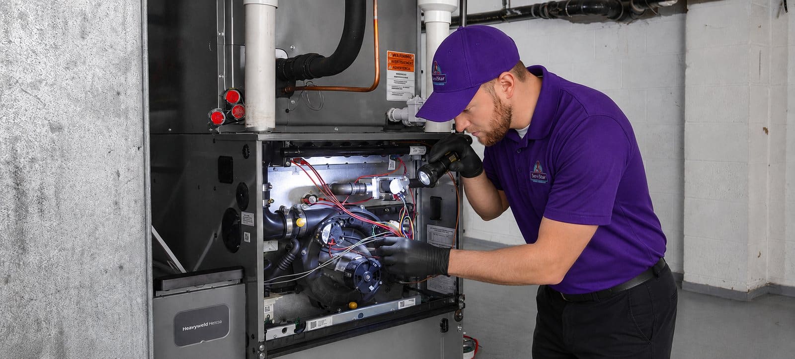 ServiStar technician repairing a furnace