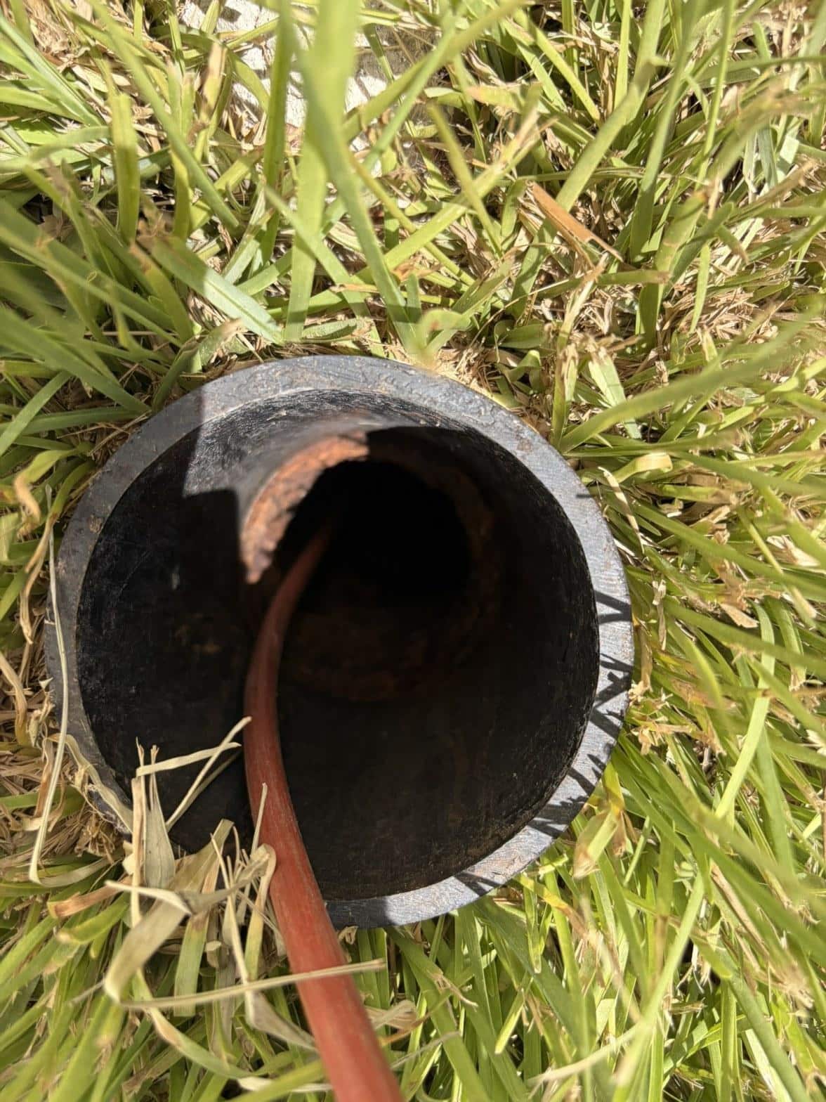rusted cast iron pipe opening viewed from above in grass